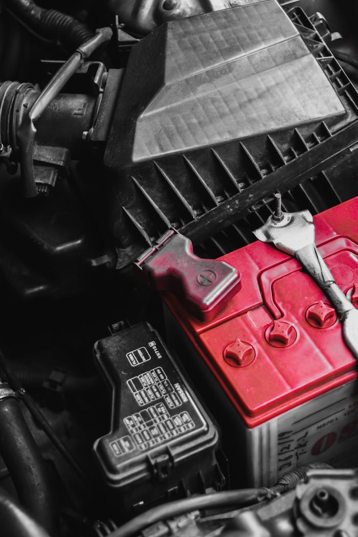 Detailed view of car battery and engine parts with wrench, focusing on repair and maintenance.